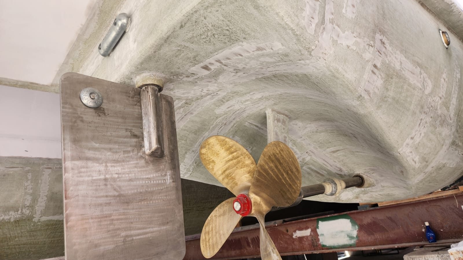 Bronze four-blade propeller, shaft and rudder fitted under a GRP hull