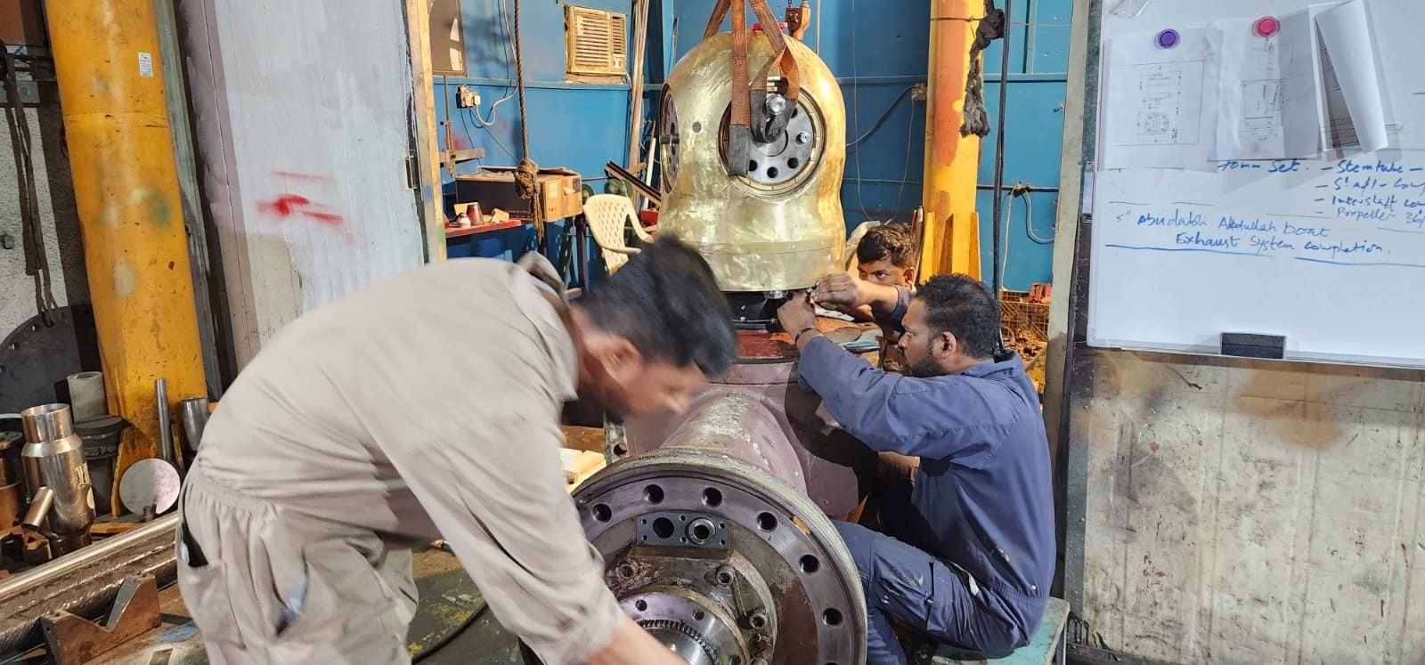 Technicians reassembling a thruster in the workshop